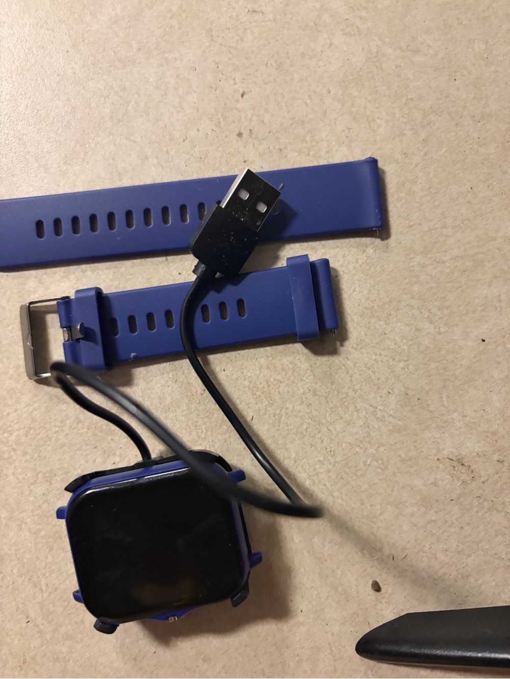Source Unknown Blue Silicone Smartwatch with USB Charging Cable.